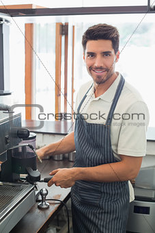 Smiling barista preparing espresso at coffee shop