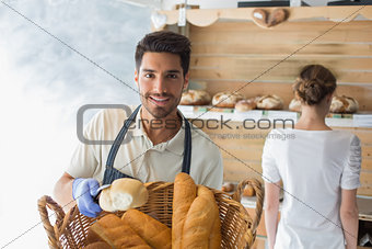 Young waiter with basket of breads at coffee shop