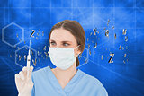 Composite image of pretty brunette female doctor holding a syringe and looking at it