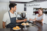 Friendly waiter giving coffee to a woman at coffee shop