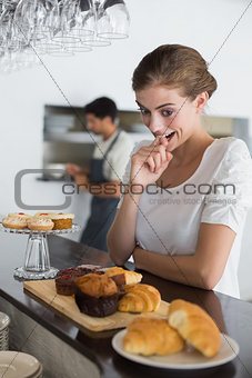 Woman looking at sweet food at coffee shop