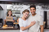 Loving couple with female cafe owner at coffee shop