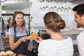 Waiter giving sweet food to a couple at coffee shop