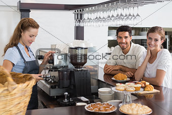 Couple with female cafe owner at coffee shop