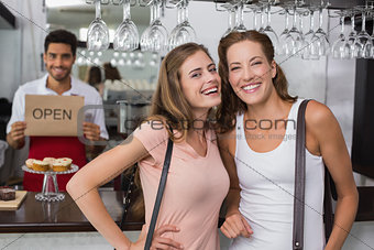 Friends with male barista at counter in coffee shop