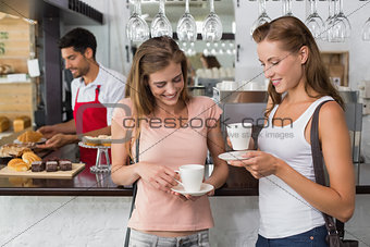 Friends with male barista at counter in coffee shop