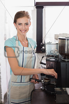 Smiling female barista preparing espresso at coffee shop