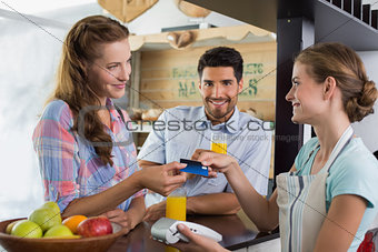 Couple paying bill at coffee shop using card bill