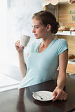 Thoughtful woman drinking coffee in coffee shop