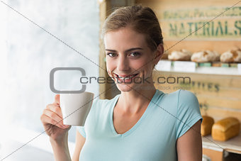 Smiling woman drinking coffee in the coffee shop