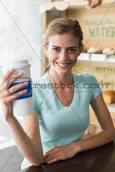 Smiling woman with coffee sipper in coffee shop