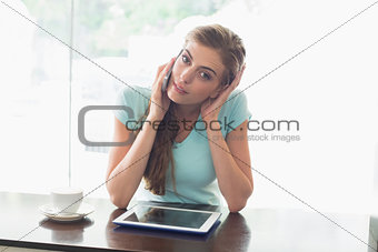 Woman with coffee cup using digital tablet and cellphone in coffee shop