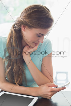 Woman with digital tablet using cellphone