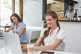 Woman using laptop in coffee shop