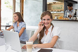 Smiling woman using mobile phone in coffee shop