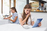 Woman using digital tablet in coffee shop