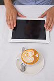 Close-up of digital tablet and coffee on table