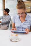 Woman using digital tablet in coffee shop