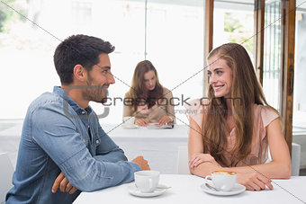 Smiling couple having coffee at coffee shop