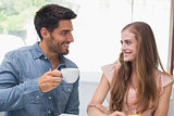Smiling couple having coffee at coffee shop