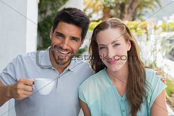Smiling couple with coffee cup at café