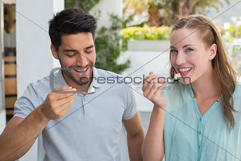 Portrait of cheerful couple eating at coffee shop