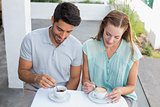 Young couple with coffee cups at café