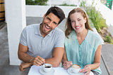 Happy young couple with coffee cups at café