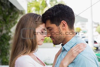 Loving young couple with eyes closed outdoors