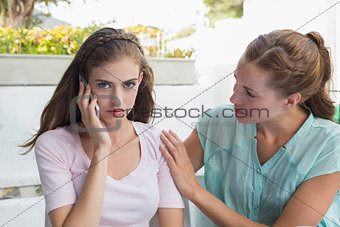 Woman consoling a friend while shes on call in café