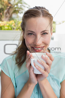 Beautiful young woman drinking coffee at café