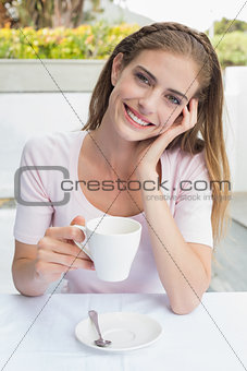Smiling young woman with coffee cup in café