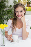 Smiling young woman with coffee cup in café