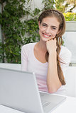 Beautiful young woman using laptop at café