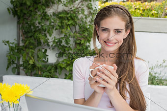 Beautiful woman with coffee and laptop at café