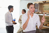 Businesswoman using mobile phone in office cafeteria