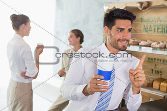 Businessman with coffee sipper at counter in office cafeteria