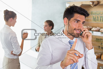 Businessman using mobile phone in office cafeteria
