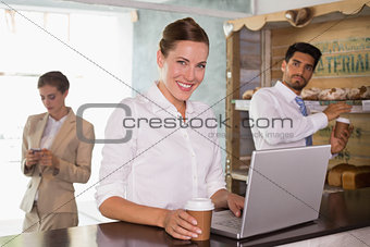 Businesswoman using laptop in office cafeteria