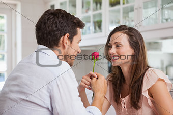 Man giving a rose to a happy woman
