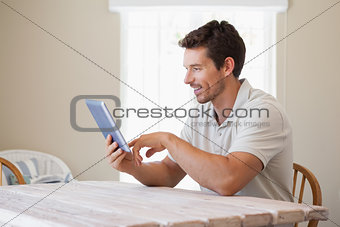 Young man using digital tablet at table