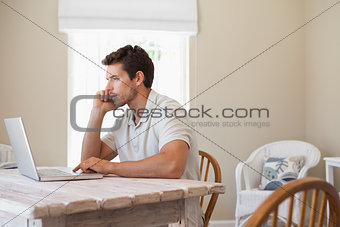 Young man using mobile phone and laptop