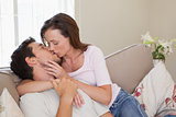 Loving young couple kissing on couch