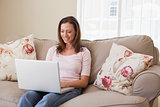 Smiling woman using laptop in living room