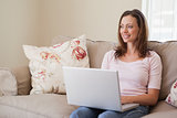 Smiling woman using laptop in living room