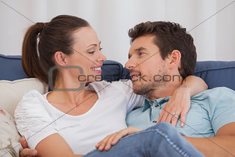 Loving couple looking at each other on couch