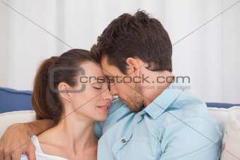 Loving couple with eyes closed on couch