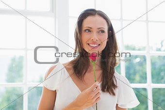 Thoughtful beautiful woman holding flower