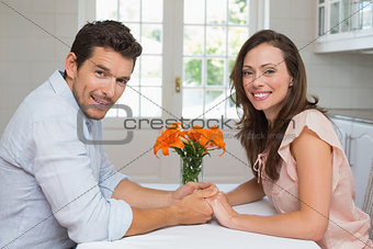 Portrait of a loving couple holding hands in kitchen