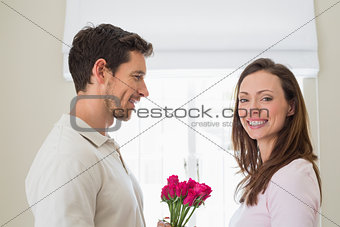 Side view of man giving happy woman flowers